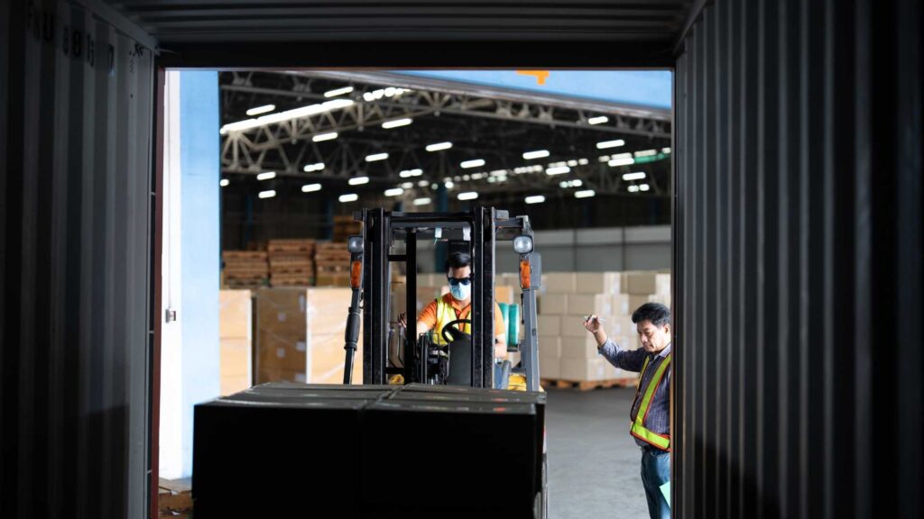 Magazziniere apre le porte in acciaio di un container