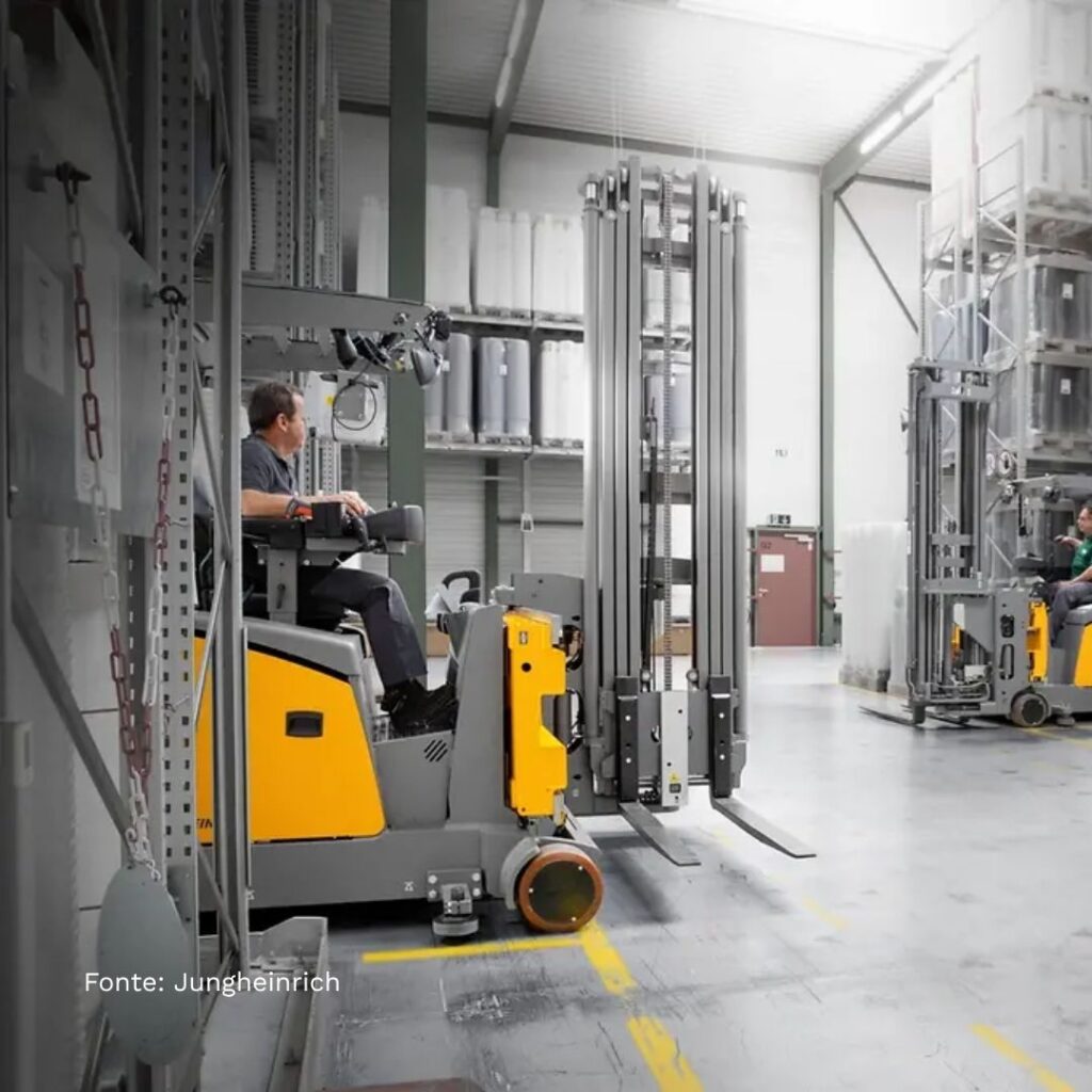 Operatore alla guida di carrello elevatore retrattile per movimentazione pallet in magazzino industriale.