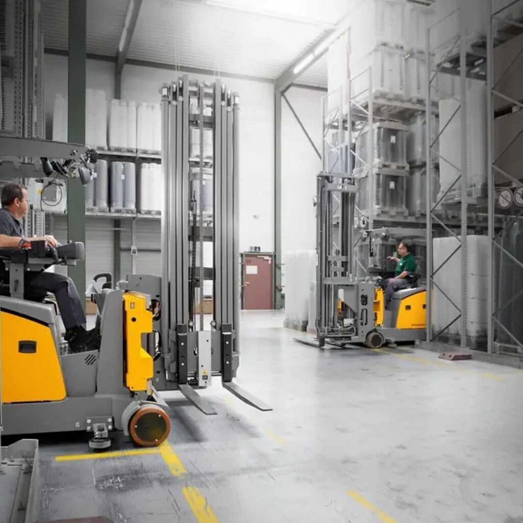 Carrello elevatore bilaterale e trilaterale giallo in magazzino con scaffalature alte