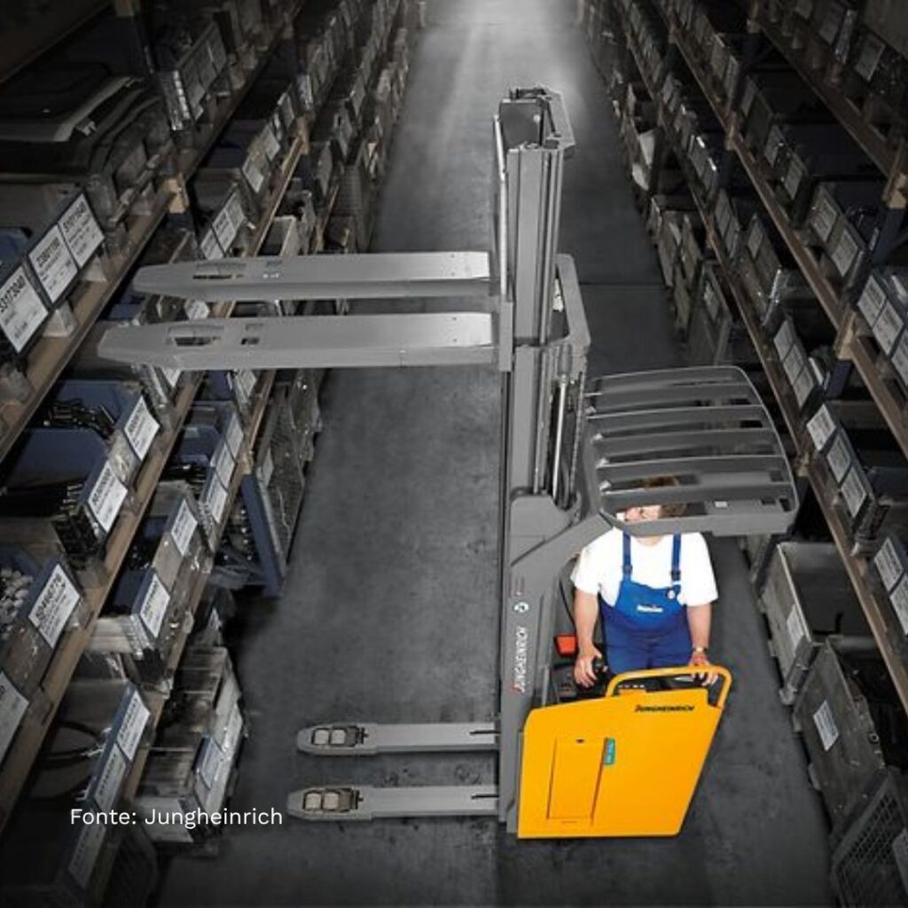 Operatore utilizza stoccatore per sollevare pallet tra scaffalature alte in magazzino verticale.